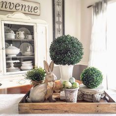 a wooden tray topped with potted plants and an easter bunny sitting on top of it