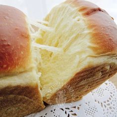 two loaves of bread sitting on top of a doily next to each other