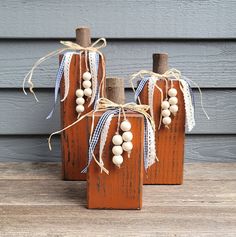 three wooden blocks with white beads and twine on them