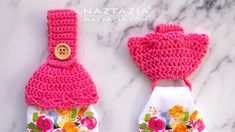 two pink mittens with flowers on them sitting on top of a marble countertop