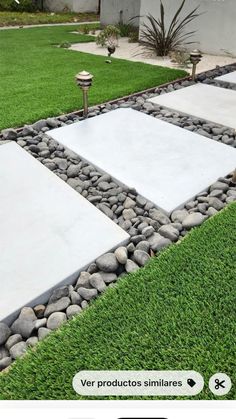 a yard with grass, rocks and stones on it that are laid out in the shape of squares