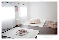 an empty room with white walls and wood flooring is pictured in this image, there are blankets on the floor