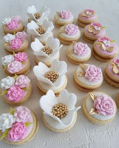 a table topped with lots of cupcakes covered in pink and white frosting