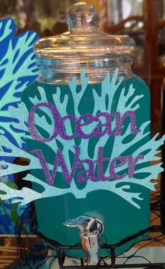 a glass jar with the words ocean water painted on it