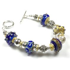 Exquisite glass Lampwork beads are the focal in this beautiful bracelet! Beautiful Sterling silver Bali Beads, and a touch of gold with 14K gold filled spacer beads, are just the right touch to highlight the colors in the beautiful glass beads. Shades of cobalt blue and navy blue, with a creamy gold hue.  Approx 8 inches. Free resizing. When purchasing this bracelet, please let me know what size you need in the comment section. Navy Bracelet, Lampwork Jewelry, Glass Bead Bracelet, Glass Lampwork, Bracelet Bead, Beads Bracelet Design, Bracelet Blue, Glass Bracelet, Glass Beaded Bracelets