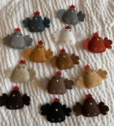 a bunch of small stuffed animals laying on top of a white bed sheet with red and yellow hearts