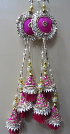 some pink and white ornaments hanging from a wall