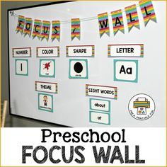 a white board with words and pictures on it that say preschool focus wall, which is decorated with colorful flags