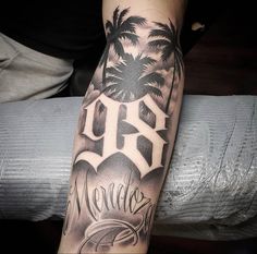 a man with a tattoo on his arm that has the word love and two palm trees