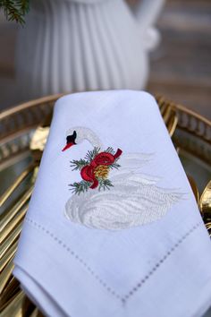 a white napkin with a red and black bird on it sitting on a gold tray