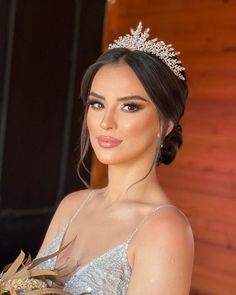 a woman wearing a tiara and holding a bouquet