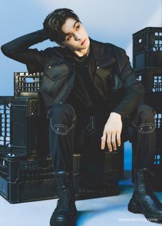 a young man sitting on top of crates