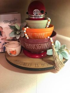 a stack of colorful bowls sitting on top of a table next to a cookbook