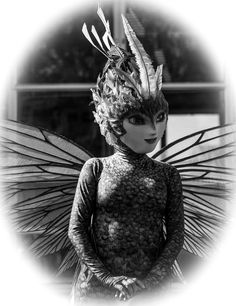 a black and white photo of a woman wearing a costume with wings on her head