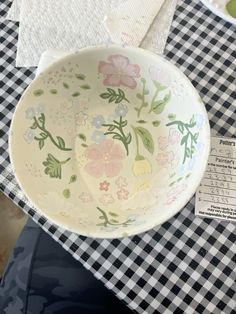 a bowl sitting on top of a checkered tablecloth covered table with paper napkins