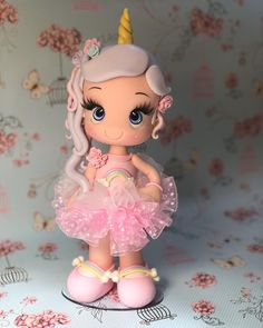 a little doll with a pink dress and unicorn horn