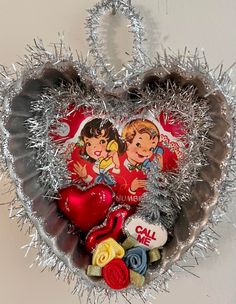 a heart shaped tinsel hanging on the wall with valentine's day decorations in it