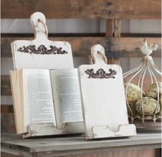 two bookends are sitting next to an open book on a table with other books