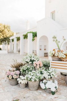 flowers are arranged in buckets on the ground