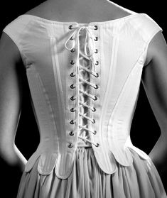 "Exemplify seventeenth century elegance in this shapely corset. This corset is rigidly boned with closely spaced 1/4\" steel bones and is cut to enhance and lift the bust, and shape the waist. The waist tabs, cut in one with the corset, curve over the hips. The shoulder straps form the high back and off the shoulder neckline, a hallmark of this period. This style is also available without tabs. Features include: Ø Side seam alteration point for an adjustable fit Ø Center back lacing Ø Shoulder s Stays Corset, Ren Faire Costume, Women's Chemises, Hoop Skirt, White Woman, Corset Lingerie, Comfort Wear, Corsets, 17th Century