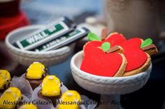 there are some cookies in the shape of an apple and yellow cars next to each other