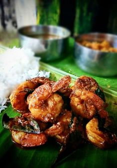 shrimp and rice on a banana leaf with other dishes in the backgroung