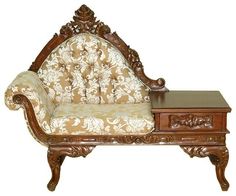 an ornately carved wooden couch with a table underneath it