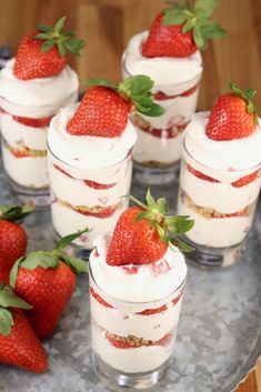 small desserts with strawberries are arranged on a silver platter, ready to be eaten