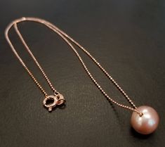 This necklace features a beautiful pink 10mm freshwater pearl. Beautiful pearl dangles on a sterling silver beaded chain rose gold plated (Vermail) that closes with a sterling silver spring ring clasp. All materials are sterling silver. Rose Gold Pearl Necklace With Round Beads For Gift, Pink Pearl Jewelry, Multicolor Pearl Necklace, Single Pearl Pendant, Single Pearl Necklace, Pearl Drop Necklace, Pearl Jewels, Long Pearl Necklaces, Cultured Pearl Necklace