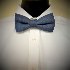 The Men's Pretied adjustable denim bow tie is a great accessory to wear when you want a dressy but casual look. The bow tie is made of a cotton denim fabric.  The bow tie is 5.5 Inches long with an adjustable neck strap that can accommodate a 20 inch neck.  The bow tie features a navy  bow behind the printed fabric and navy cotton necks strap.