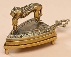 an antique brass plated figurine of a dog on top of a stand