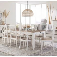 a dining room table with chairs and a rug