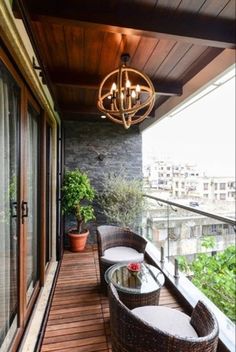 a balcony with wicker furniture and a chandelier hanging from it's ceiling