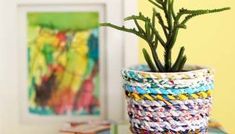 a small potted plant sitting on top of a book next to a framed painting