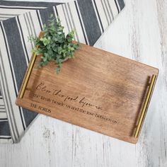 a wooden cutting board with writing on it and a plant in the corner next to it