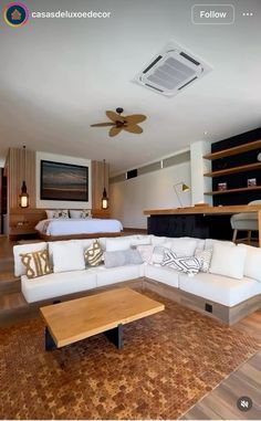 a living room filled with furniture and a flat screen tv mounted to the wall next to a bed