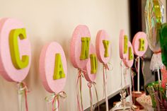 pink and green candy letters are hanging on the wall