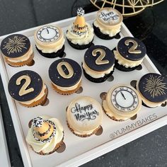 twelve cupcakes decorated with gold and black numbers