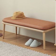 a hat and slippers are sitting on a bench in front of a white wall