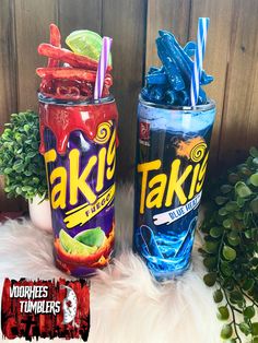 two plastic cups filled with different flavored drinks next to each other on top of a white fur rug