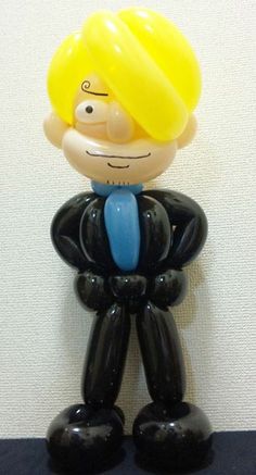 a black and yellow toy with a man's head in the shape of a balloon