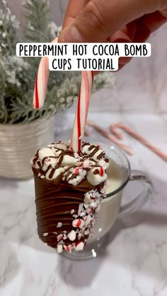 there is a chocolate cupcake with candy canes in it and the words peppermint hot cocoa bomb cups