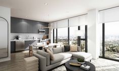 a living room filled with furniture and lots of windows next to a window covered kitchen