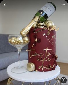 a red cake with gold decorations and a bottle of wine