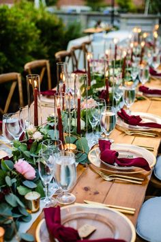 a long table set with place settings and candles