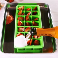 a tray with strawberries and ice cream being poured into it