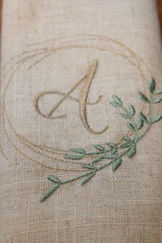 embroidered monogrammed linen with green leaves on it