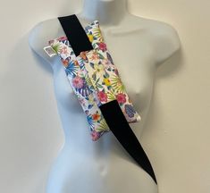 a white mannequin wearing a colorful floral sling