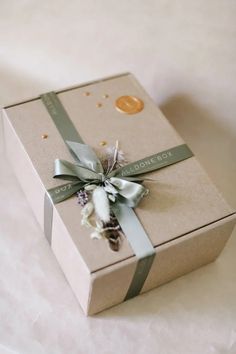 a gift box with a ribbon and flower on it