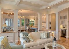 a living room filled with furniture next to a kitchen